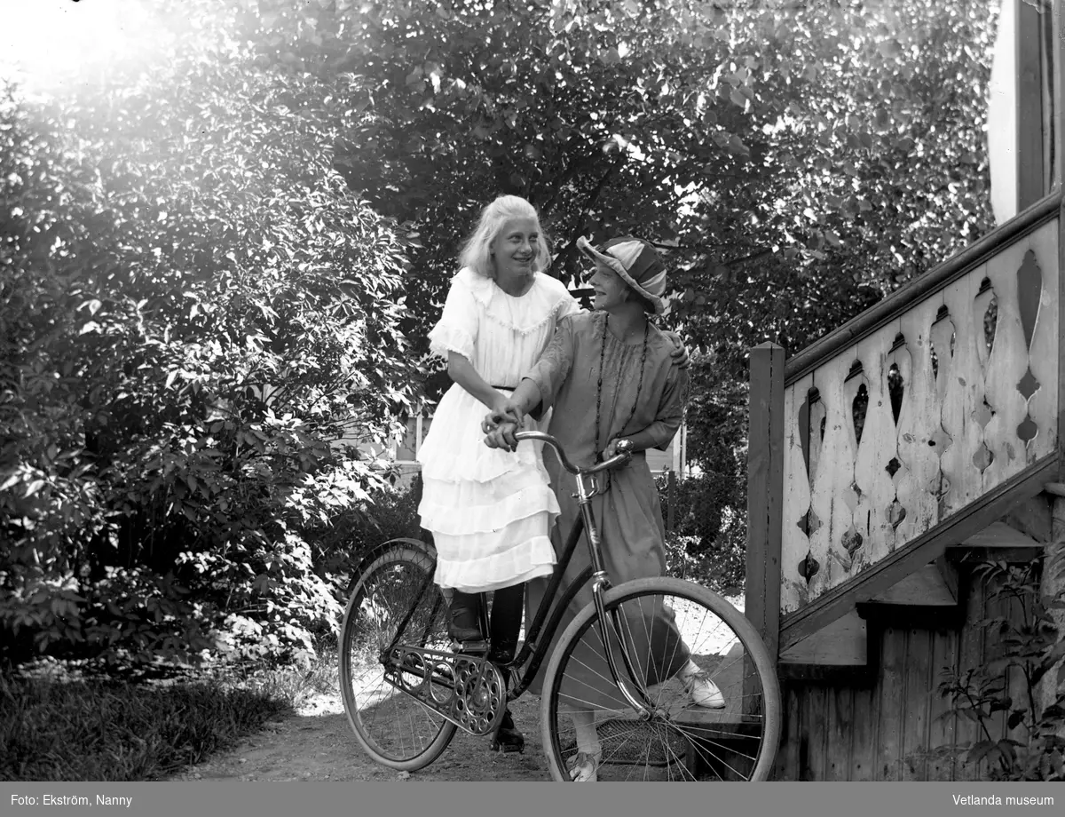Anna Karin och en oidentiferad flicka med en cykel. Anna Karin var dotter till fotografen Nannys syster Amy. Bilden är tagen framför fotoateljén.