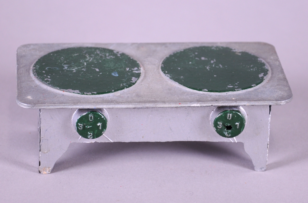 Lekekomfyr av metall, med grønne kokeplater.