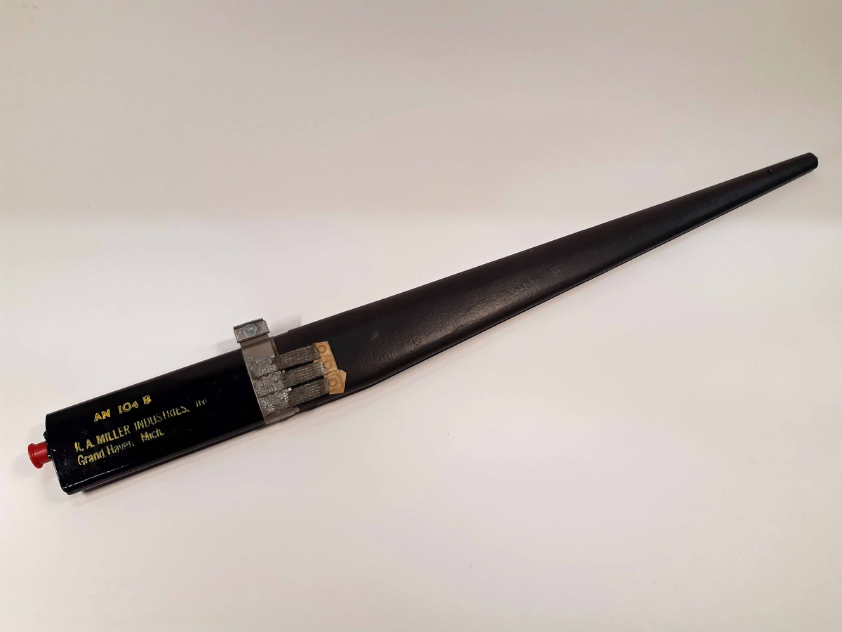 Antenn, AN 104 B, svartlackerad med svart gummering. På sidan märkt: "R. A. MILLER INDUSTRIES. INC. Grand Haven Mich."
Förvaras i originalförpackning av kartong, datum-märkt: 24/8 1970.