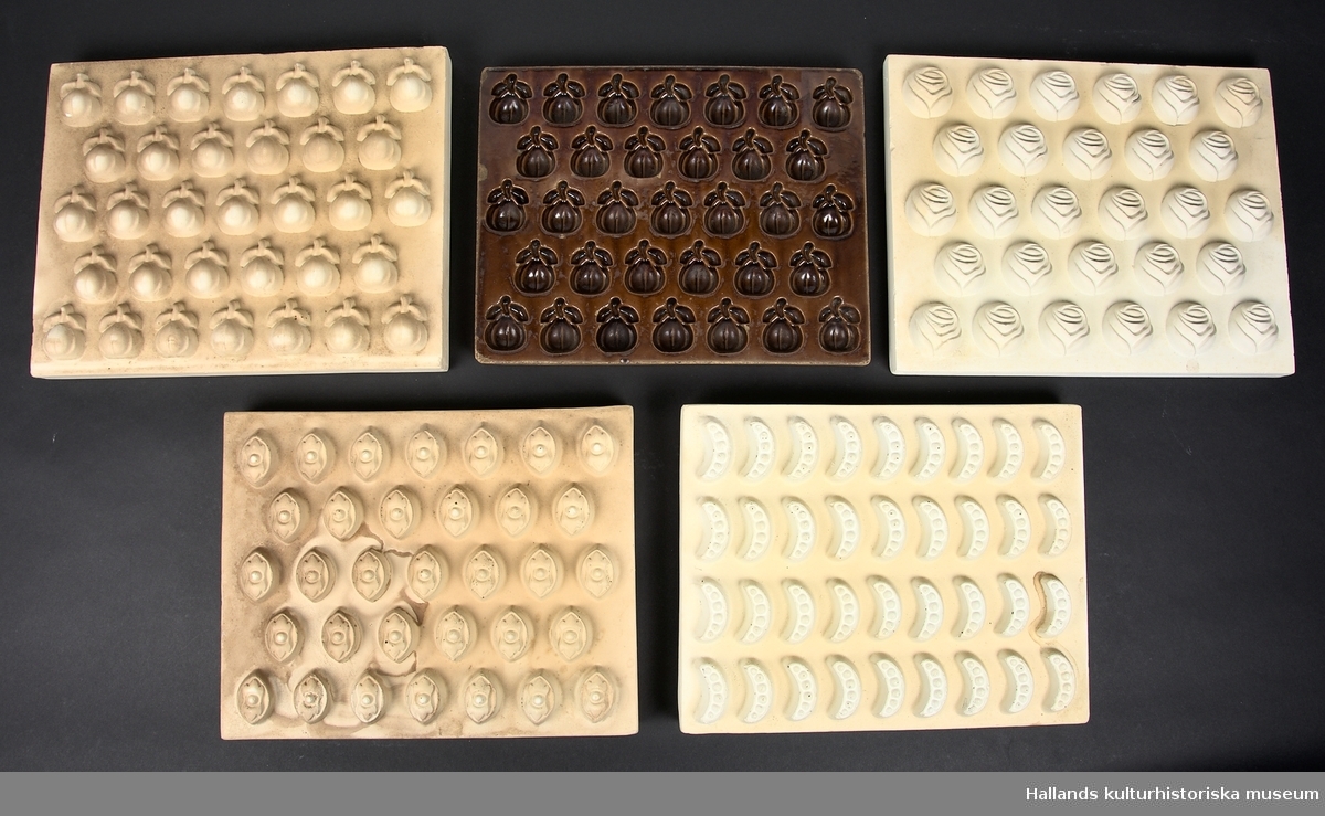 En samling bestående av fyra matriser som har använts för att tillverka former till marmeladkonfekt, samt en färdig form (a).

A: Form i brunglaserad keramik med 33 stycken äppelformade håligheter. L: 350 mm, B: 260 mm, D: 25 mm

B: Matrisform av keramik med 33 stycken geometriska mönstrade förhöjningar. L: 340 mm, B: 265 mm, D: 50 mm

C. Matrisform av keramik med 33 stycken äppelformade förhöjningar. Har använts till att pressa fram mönstret i form A. L: 360 mm, B: 282 mm, D: 60 mm

D. Matrisform av keramik med 33 stycken tandradsformade förhöjningar. L: 335 mm, B: 265 mm, D: 55 mm

E. Matrisform av keramik med 28 stycken rosformade förhöjningar. L: 360 mm, B: 282 mm, D: 45 mm