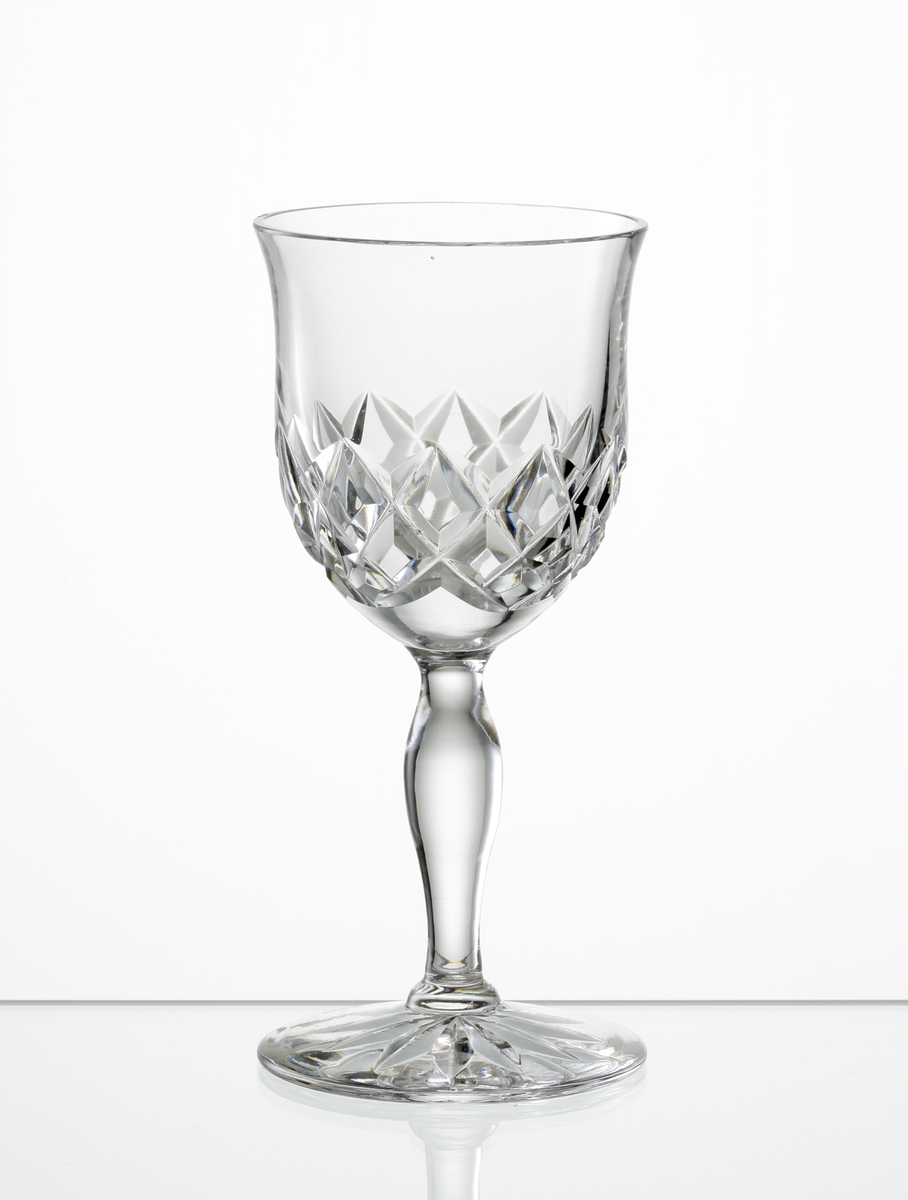 Design: Okänd. 
Portvinsglas. Klockformad kupa med skärslipad dekor. Vulsterben, fot med stjärna i botten.