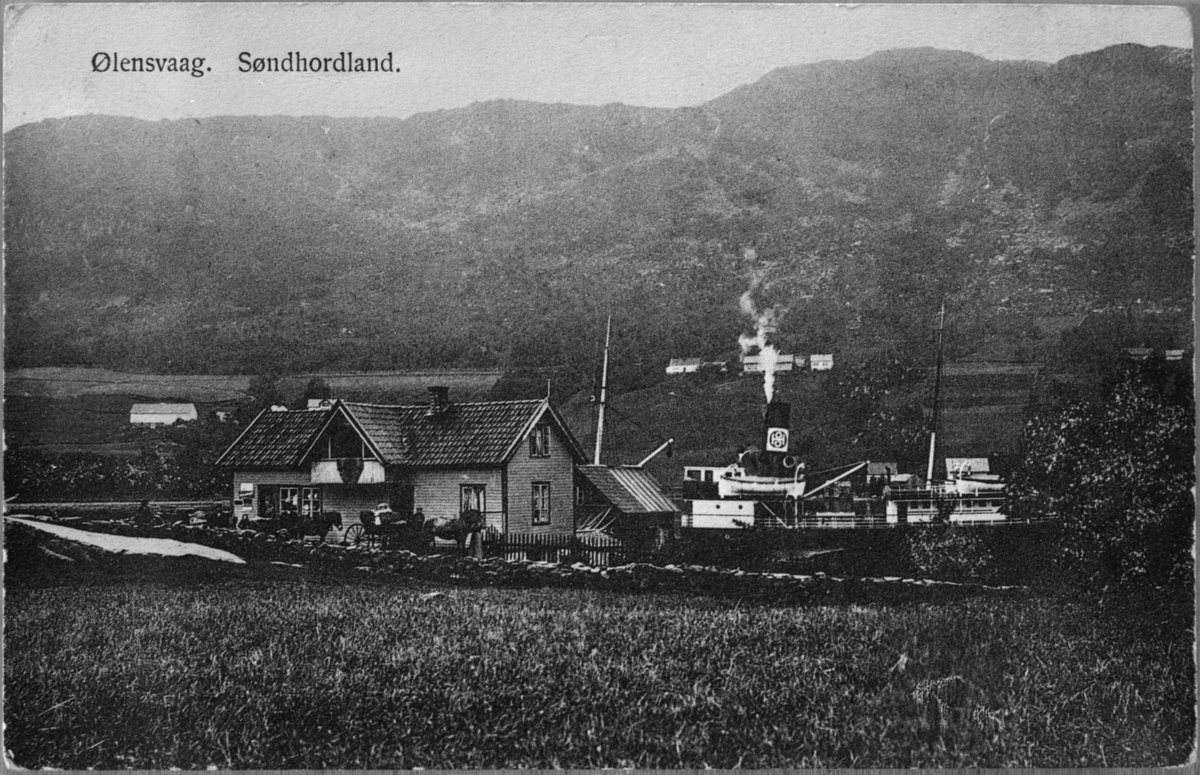 Den gamle krambua i Kvassanes i Ølensvåg, ca. 1915. Krambua var bygd i 1908-09. Eit dampskip frå HSD ligg til kai.
