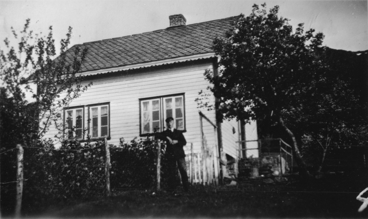 Huset til Gjertrud Flatebø på Haugsgjerdet i Bjoa, ca. 1940. Ståande foran huset er Ole A. Tvedt.