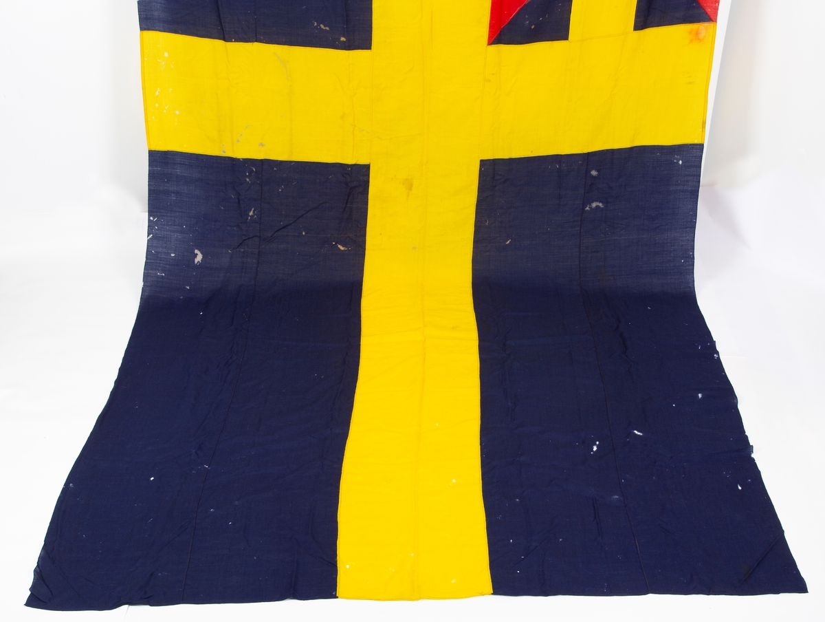 Svensk flagg med unionsmerke, "sildesalaten". Metallhempe. Møllspist og slitt.
Unionsmerket: 120 x 103

Givers datter opplyser at flagget var kjøpt på auksjon eller loppemarked på 1980 tallet. Det skal ha kommet fra båtbyggeriet på Kugrava i Son.