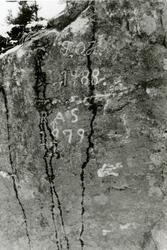 Årstall og initialer hogd i fjellvegg på  fylkesveg 42 i Myk