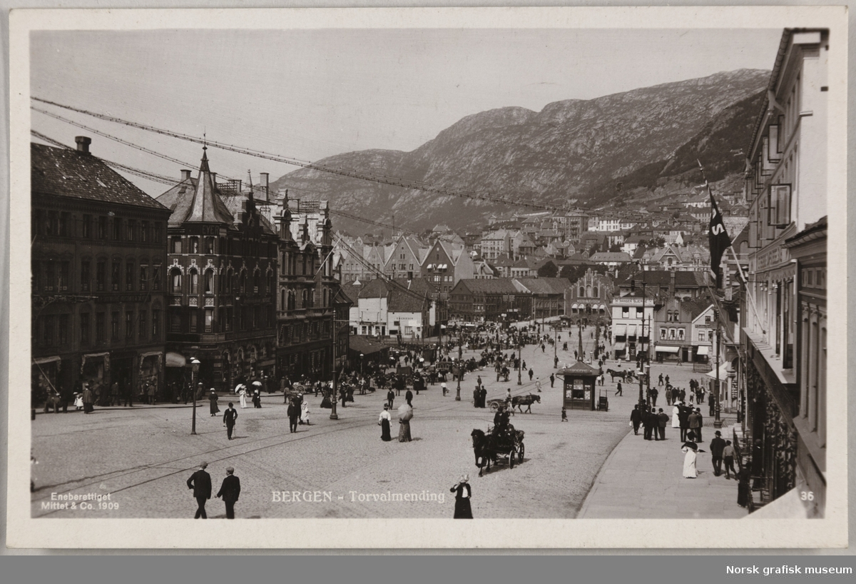 Postkort med motiv nedover Torgallmenningen mot bryggen i Bergen. Det er mange folk i gatene.