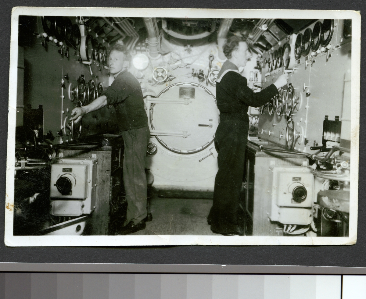 Bilden visar två sjömän som arbetar i e-rum på ubåten Najad.