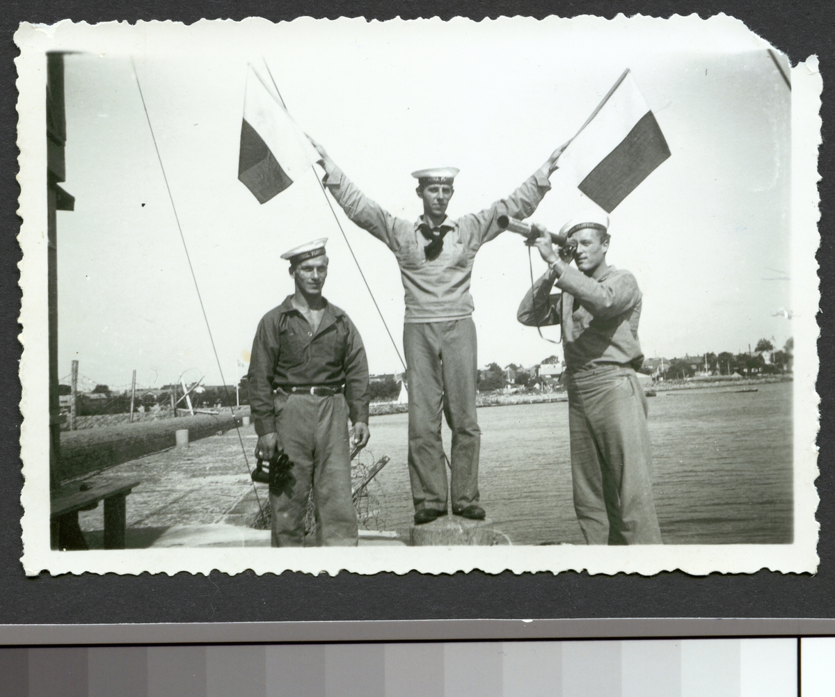 Bilden visar Gösta och två andra sjömän som hanterar med signalflaggor och kikare.