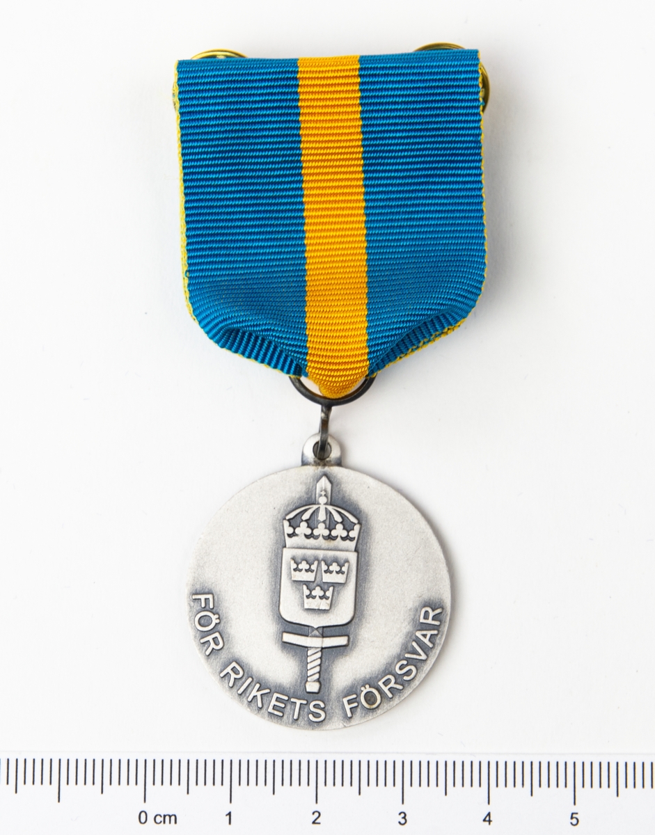 Framsidan har det svenska nationalitets vapnet med tre koronor och ett svärd med texten "För rikets försvar". Baksidan har en lagerkrans samt texten F 4 Gu 04/05.
Förvaras i originalask.