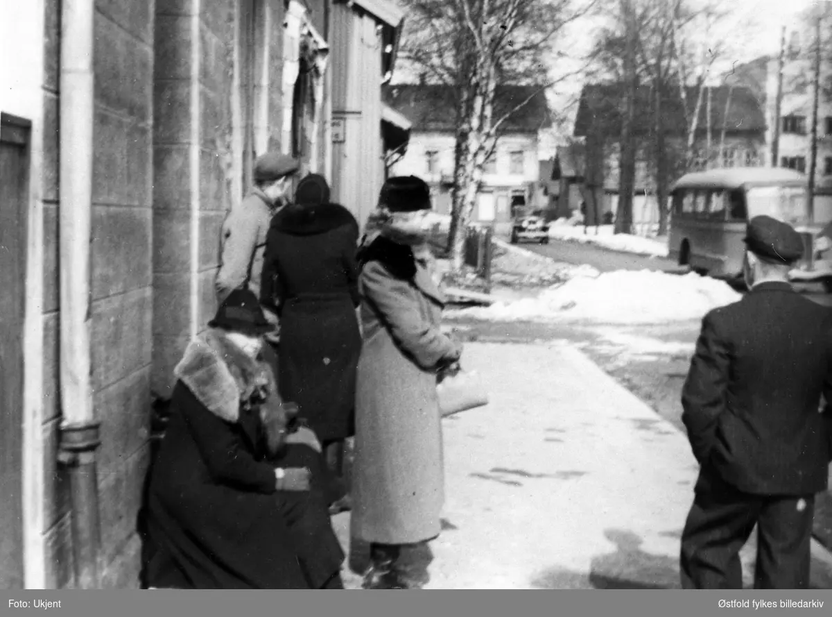 Lillestrøm 9. april 1940, folk venter på evakueringsbuss til Toten. Medlemmer av familien Erikstad  er med på bildet.