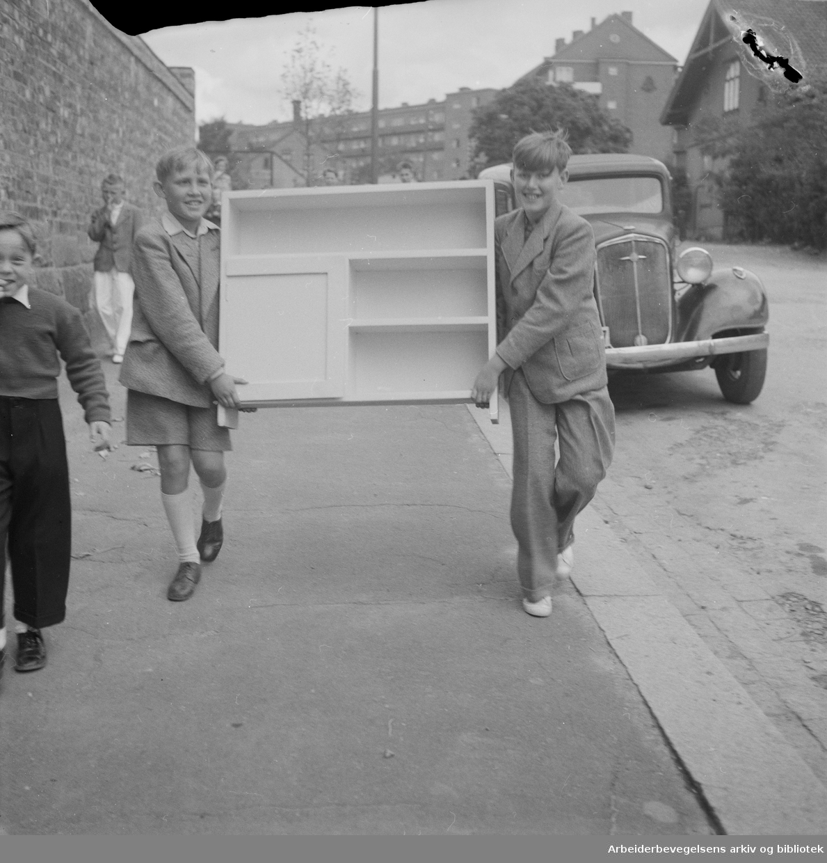 Siste skoledag før sommerferien. Bokhylla fra sløyden bæres hjem. Juni 1950.