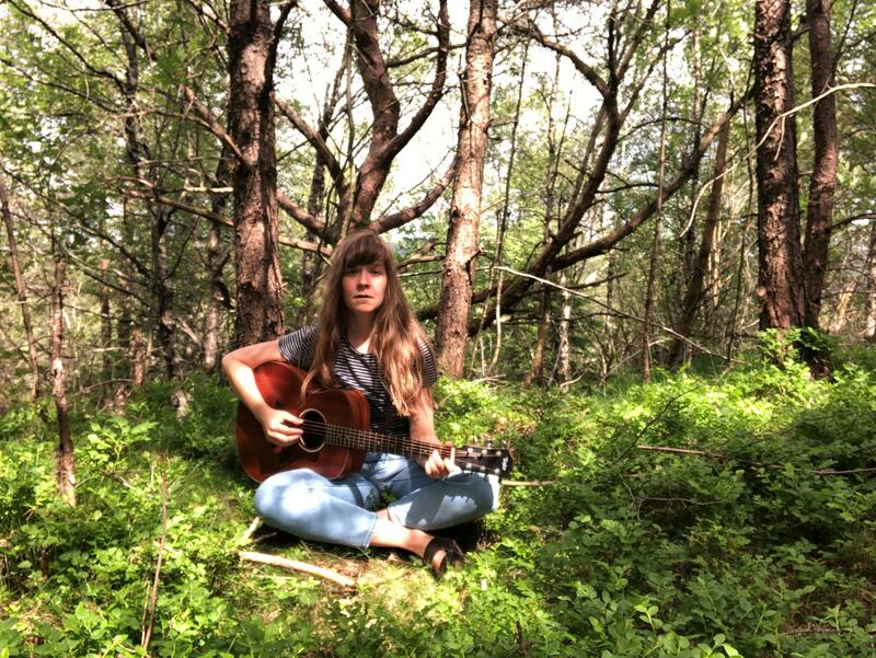 Stine Norse spiller gitar i skogen