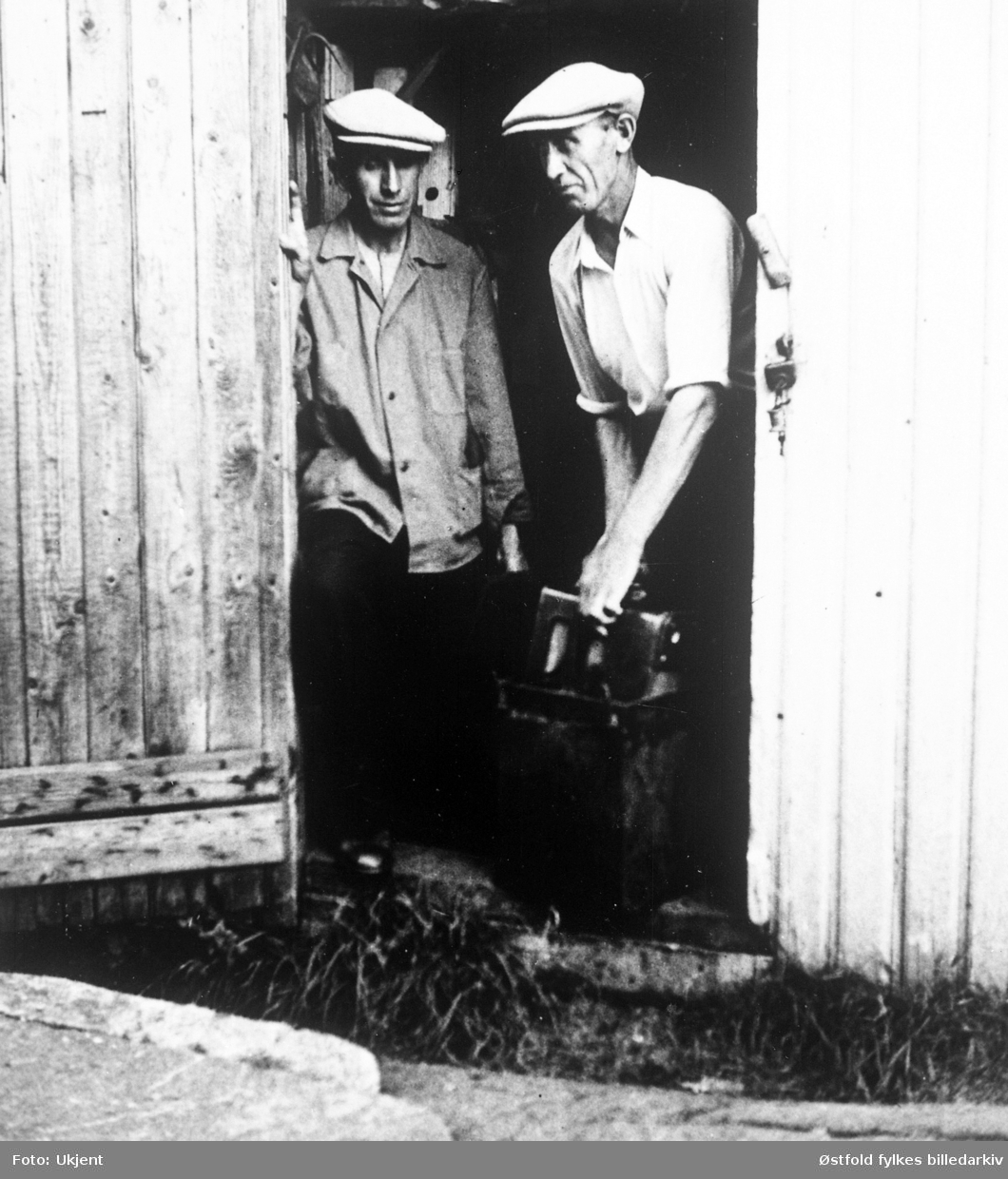 Brødrene Hans og Kr. Wergeland, Glombo  på Kråkerøy, holder radioapparat som var gjemt i appelsinkasse under andre verdenskrig.