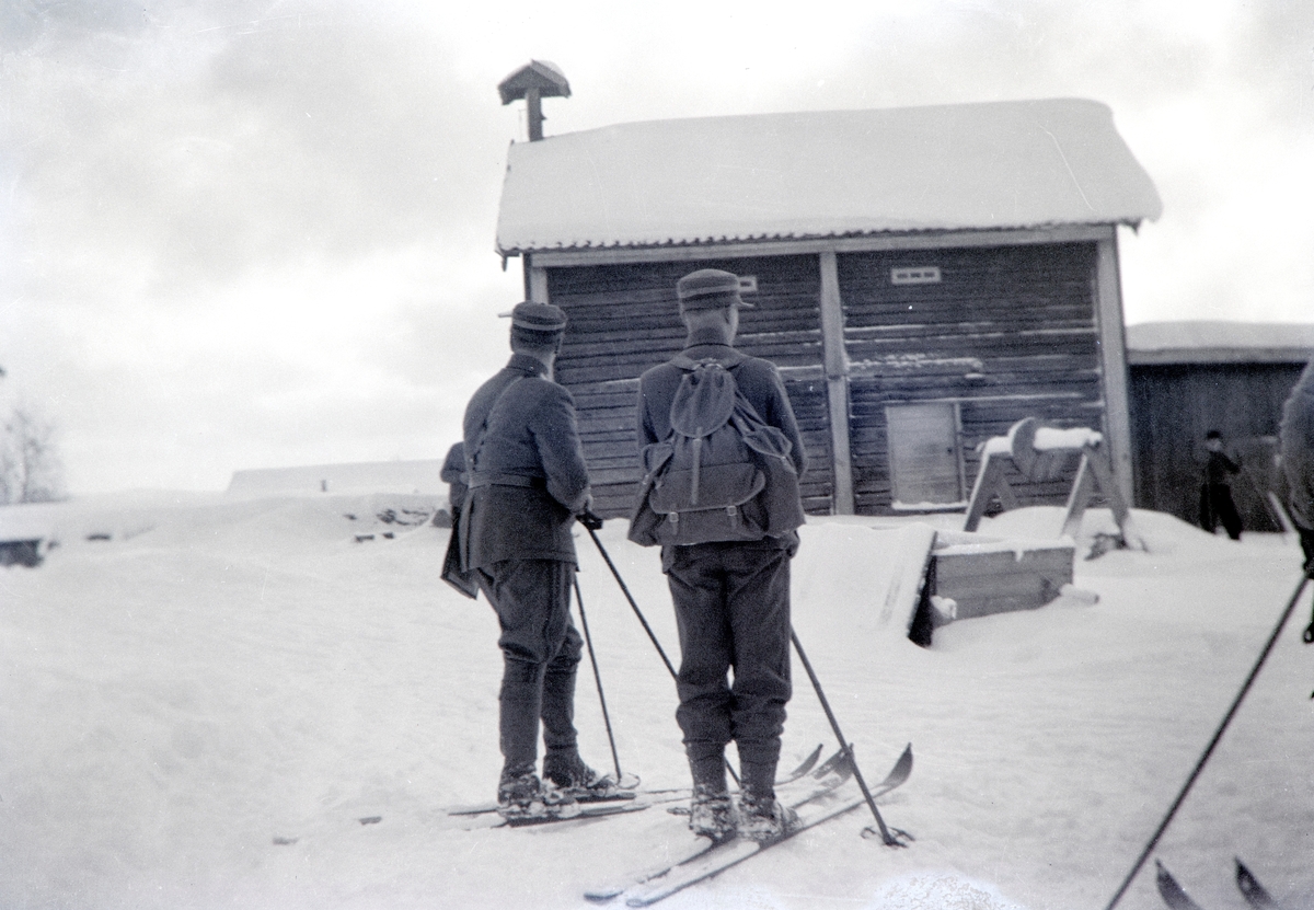 Militærøvelse i Romedal 1937. Vinterøvelse. Kronprins Olav var tilstede under øvelsen. Vinter, snø, ski, militæret.
Ved stabburet i Haukåsen, Romedal.