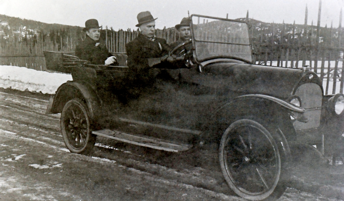 Hans Ljøterud med sin første bil i 1920. Ove Ljøterud (1898-1920)
sitter ved siden av sjåføren.
Logo på radiatorkappa (oval med diagonalt midtfelt) tilsier at det er en Overland, populært amerikansk merke den gang. Hesteskoformet radiatorkappe tilsier 1918-19-modell, evt. eldre.