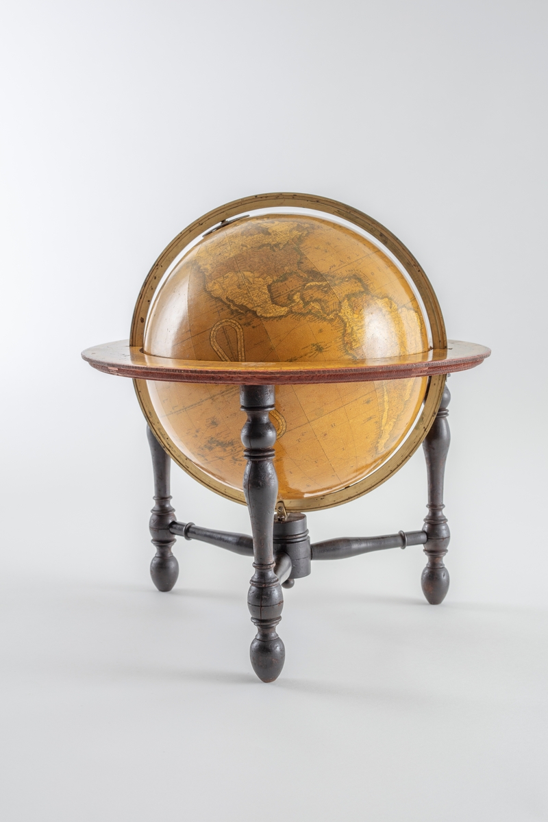 Globus som er montert på et stativ med tre ben, dreid i tre, malt mørk brunt.