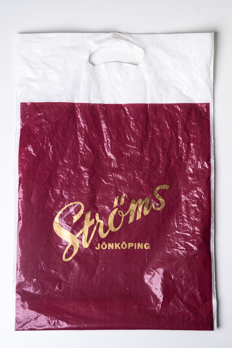 Kasse av rost-röd och vit plast med tryckt text i guld: "Ströms JÖNKÖPING", Använd.