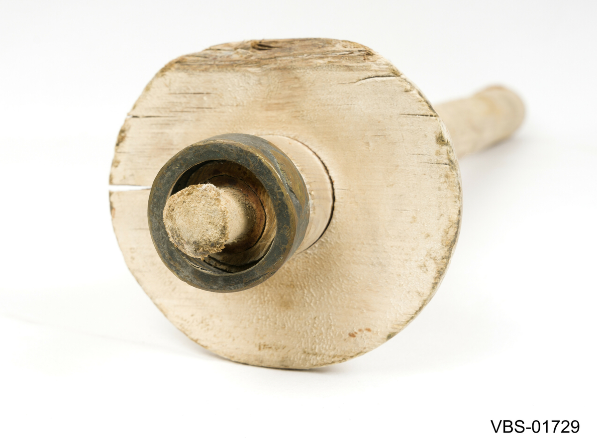 Rund seksjon trestaur med en koniskmessing ring. 
Trestykk som en del av en pumpe, trolig brukt i en lensepumpe til båt.