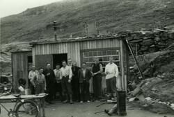 Ti menn foran en brakke i Hammerfest