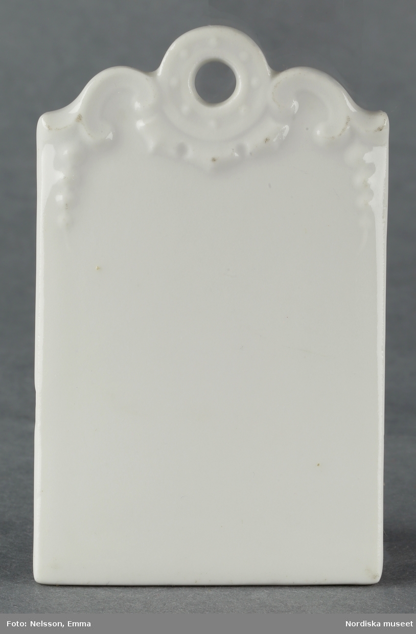 Inventering Sesam 1996-1999:
L 9  B 5,7  (cm)
Skärbräda av vitglaserat porslin, rektangulär med profilerad ände med reliefmotiv. 
Tillhör dockskåp inv 192.991.
Birgitta Martinius 1996