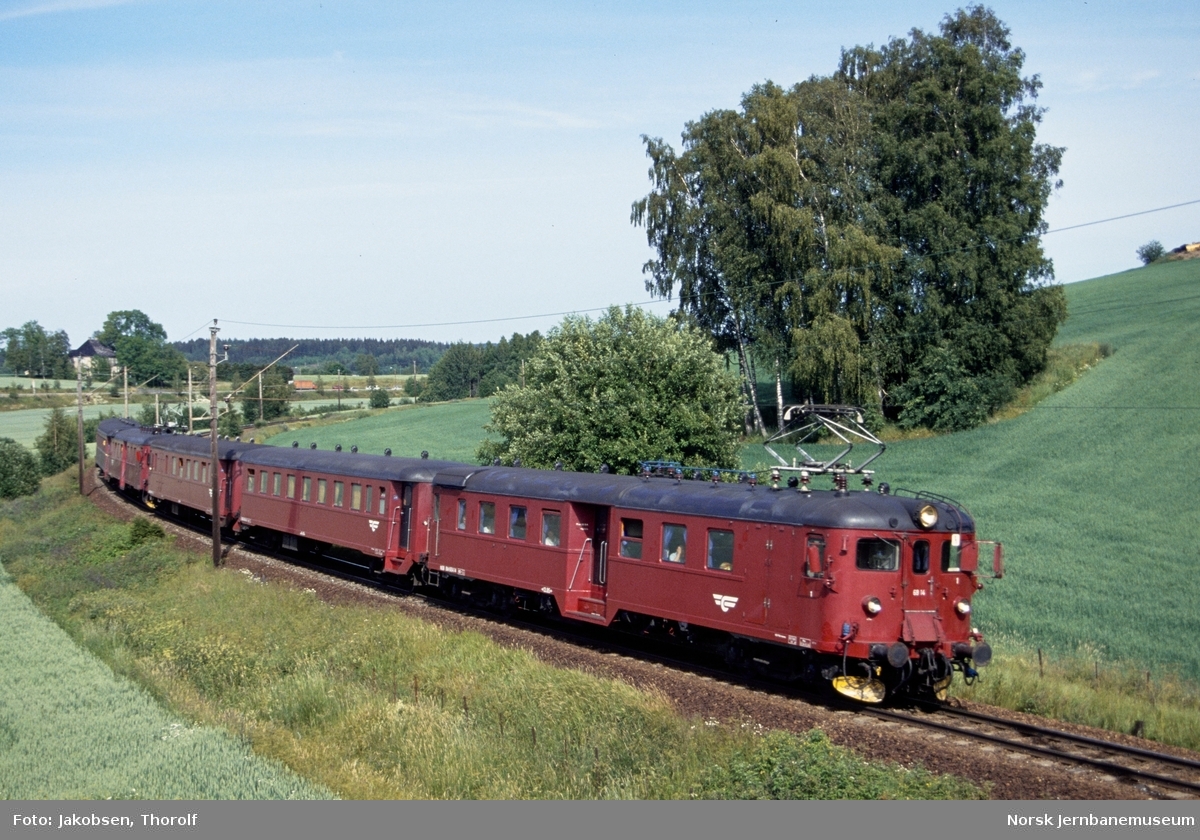 Elektrisk motorvognsett type 68A med persontog til Halden, tog 123, ved km 28,5 like syd for Holstad stasjon på Østfoldbanen