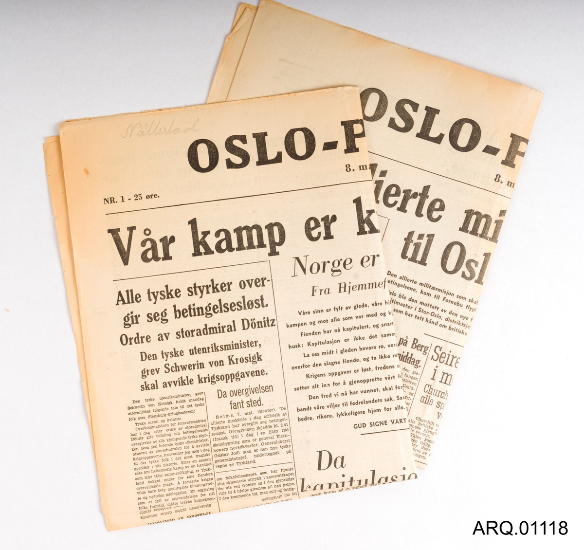 To stykk aviser fra Oslo-Pressen. Nr. 1 og Nr. 2, 8. mai 1945. "Vår kamp er kronet med seier." og "Den allierte militærmisjon kom til Oslo i dag." Avisene har artikler rundt temaet friegjøringen og det som har skjedd dagene før 8. mai. 25 øre.