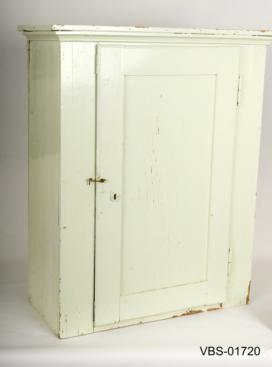 Håndverk hengeskap. Skapet har to innvendige hyller og en sentral dør.
Det har en gammel grønn malt lås (nøkkel mangler) og en liten, mer moderne messingstift.
