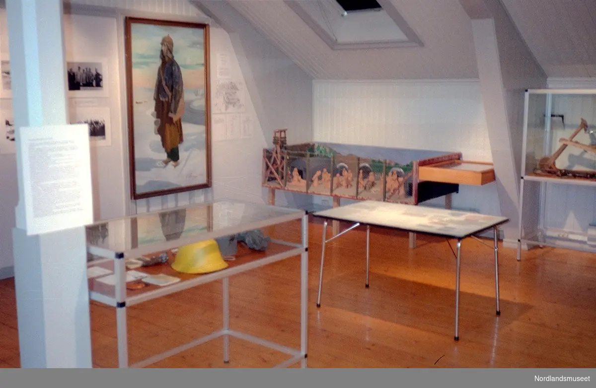 Fra temautstillingen "Fra Bodø i krigstiden 1940-45" i Nordlandsmuseet, fra 8. mai 1995 og ut året, 2 utstillingsmontre og et bord med utstillingseffekter, et maleri og noen delvis skjulte bilder på veggen, fra andre etasjen på museet.