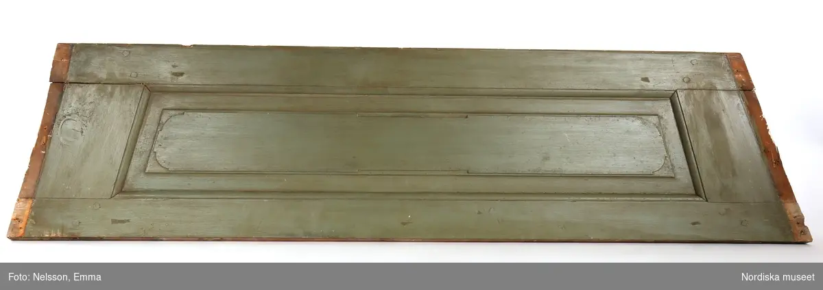 Panel, 3 st, av furu, målad i grågrön oljefärg, omkring 1740. Fyllningar med upphöjt mittparti.

Anm: Partiellt färgbortfall och skador. Panelerna har varit placerade ovanför fönstren i nischerna. 
/Anna Arfvidsson Womack 2021-07-16