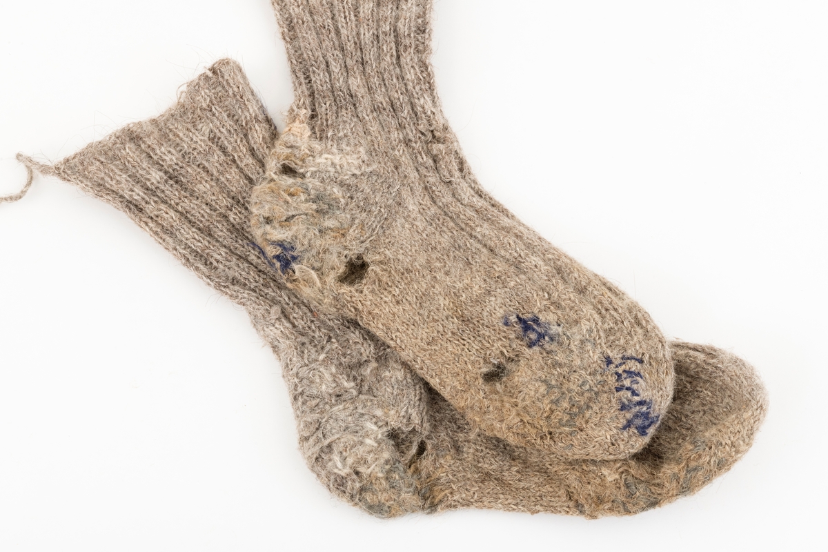 Ett par sokker som er strikket av grått ullgarn. Brukt av giverens onkel, Karl Galåsen. (1874-1962)