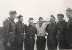 Portrettfotografi av 7 menn i militæruniform. Fra venstre: H