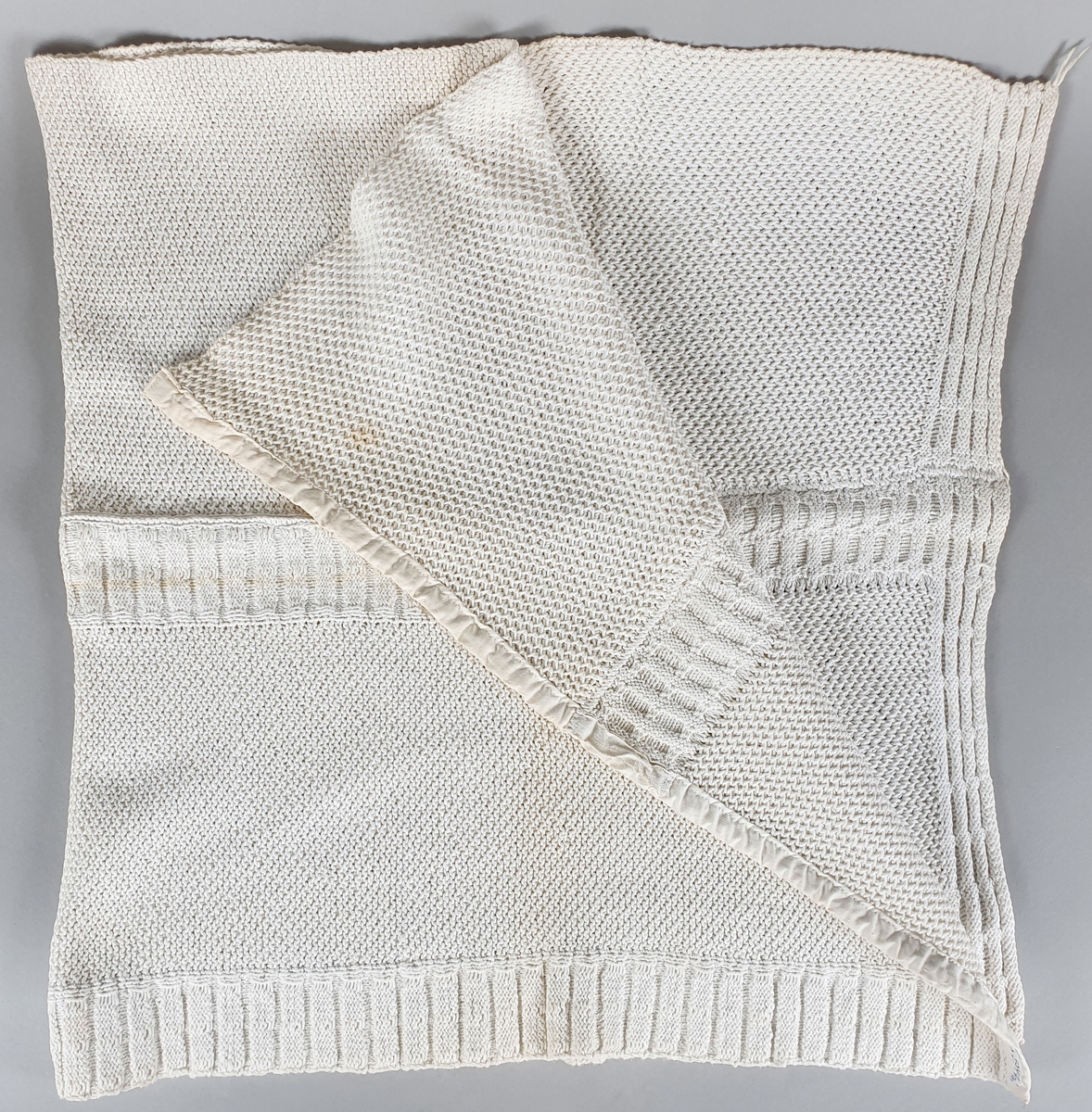 Tre strikkede kjøkkenhåndklær av bomull, kantet med bomullsbånd.