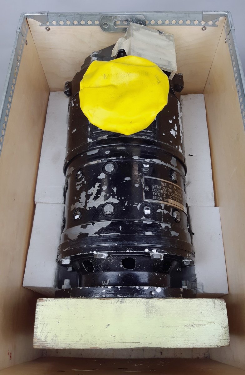 Generator P3 i svart lackad metall, försedd med ett gult skyddsöverdrag. REF.No: 5U/4750, 30 Volt, 200 AMPS. Individ-nr: 67864. Förvaras i en transportlåda märkt: "CVV", "RETUR OMG".