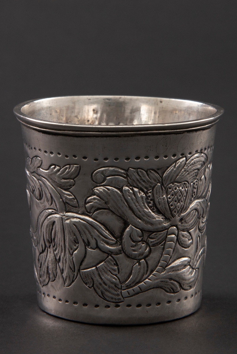 Beger i sølv med svakt konisk form og markert, utoverbøyd kant øverst. Korpus er dekorert med kraftig drevet blomster- og bladdekor.