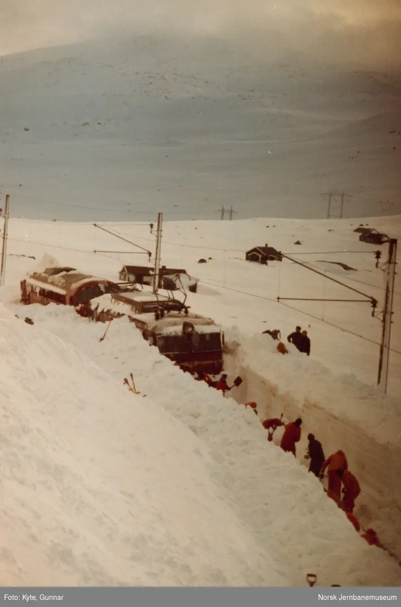 Nattoget fra Bergen til Oslo, tog 606, fastkjørt i snøen ved Oksebotn mellom Finse og Haugastøl. Toget ble trukket av diesellokomotiv Di 3 607 og elektrisk lokomotiv El 14 2188