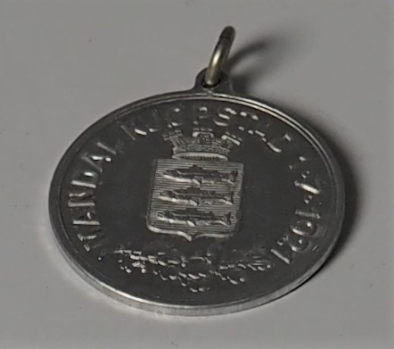 Kjøpstadsmedalje produsert for salg i forbindelse med Mandals kjøpstadsrettigheter 1. juli 2021. Medaljen ble solgt hos gullsmed Olaf G. Nilsen i Mandal. Prisen var kr 0,75 for denne i metall. Det ble i tillegg solgt en i sølv for kr 2,25.