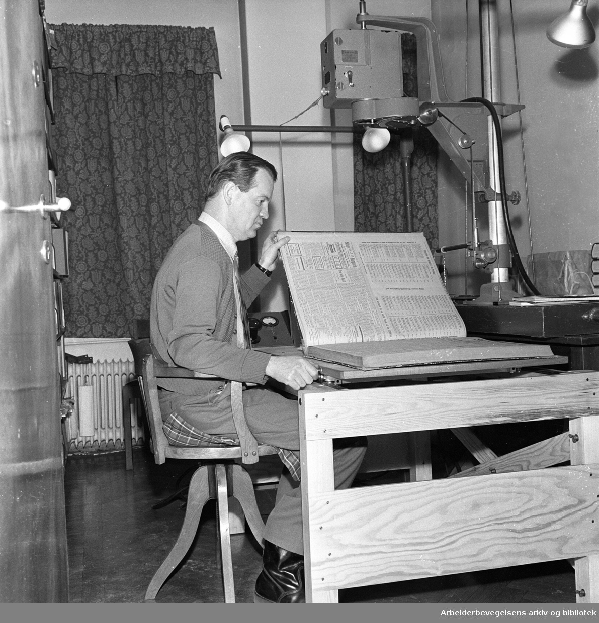 Karl Henry Andersen avfotograferer Arbeiderbladets årganger på mikrofilm. Januar 1960