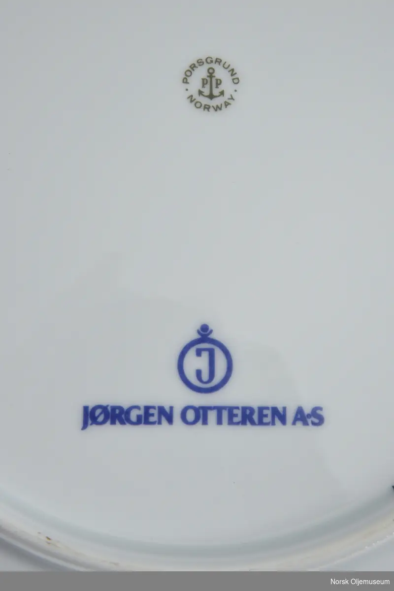 Jubileumsplatte dekorert med logo for Esso og illustrasjon av oljeplattform.