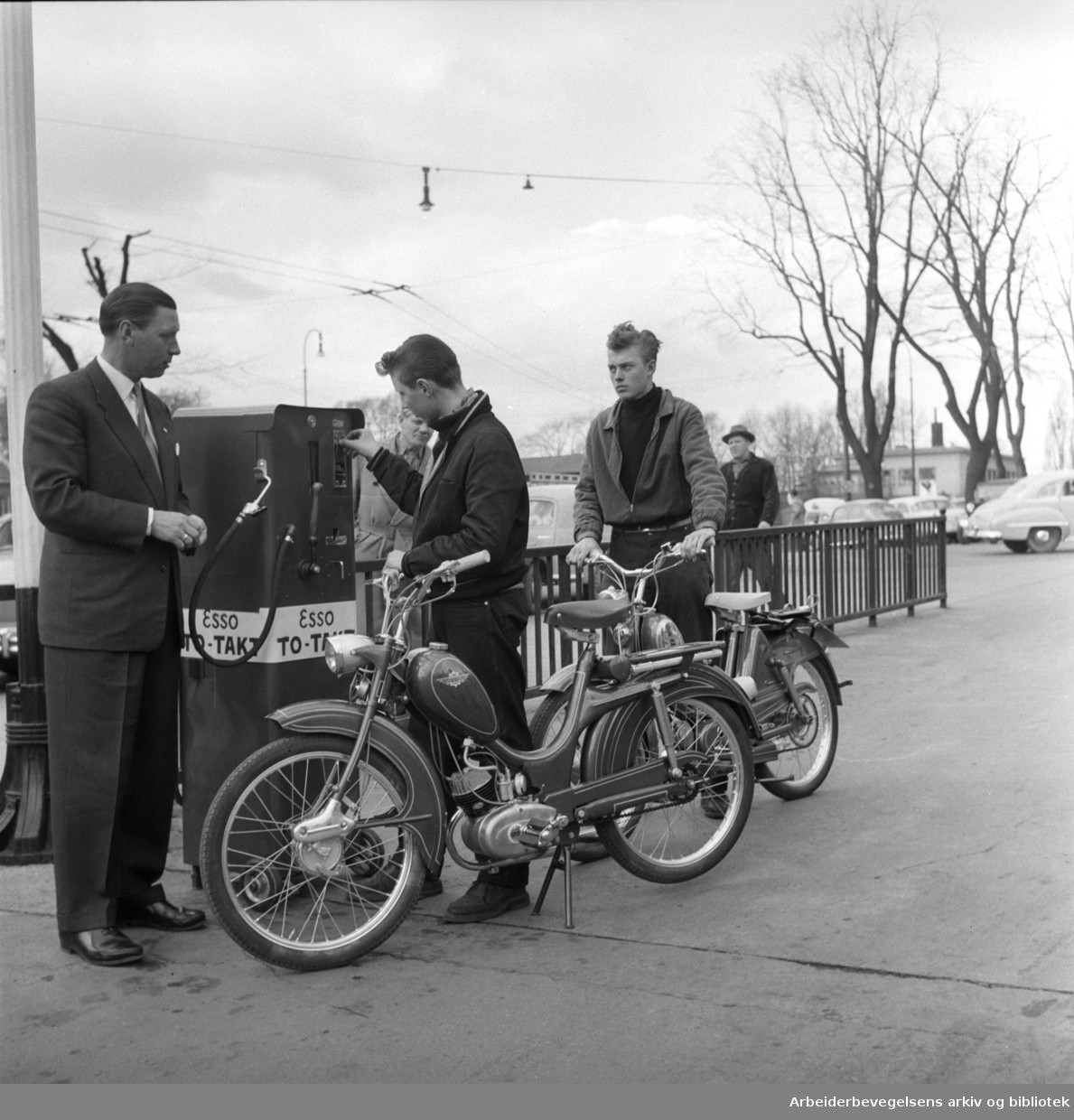 Ungdom med mopeder ved en Esso bensinautomat. Mai 1957