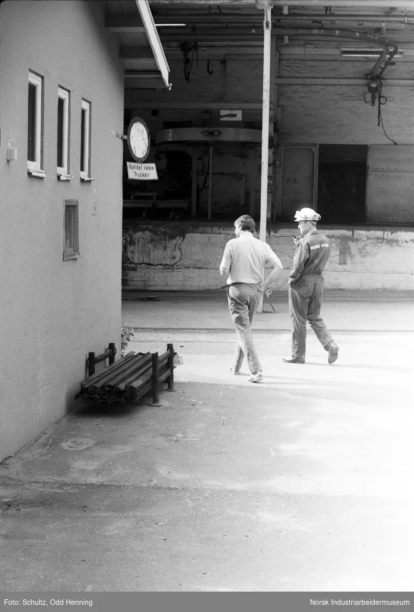 To menn spaserer vest for kontorbygningen.
