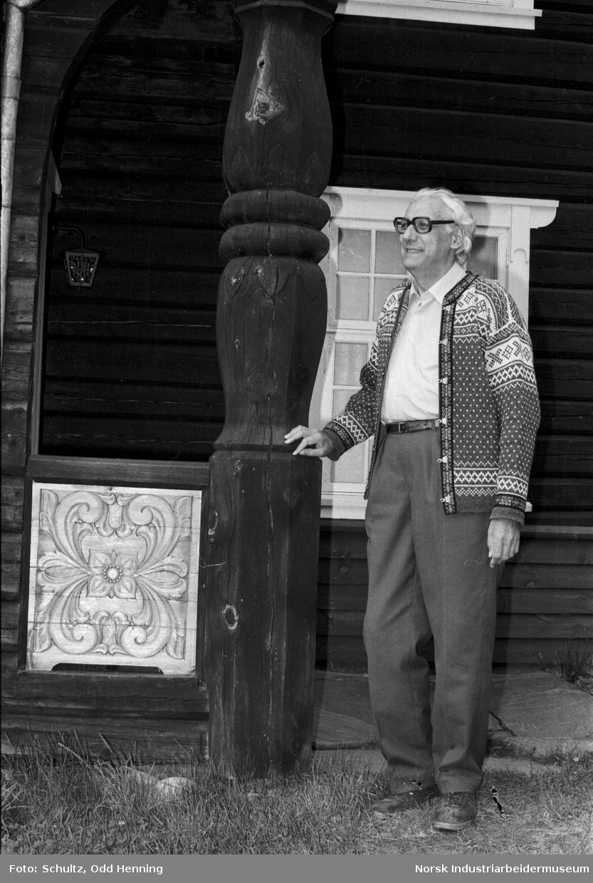 Mann ved hovedinngangen til laftehus i Øyre Gjøystdal.