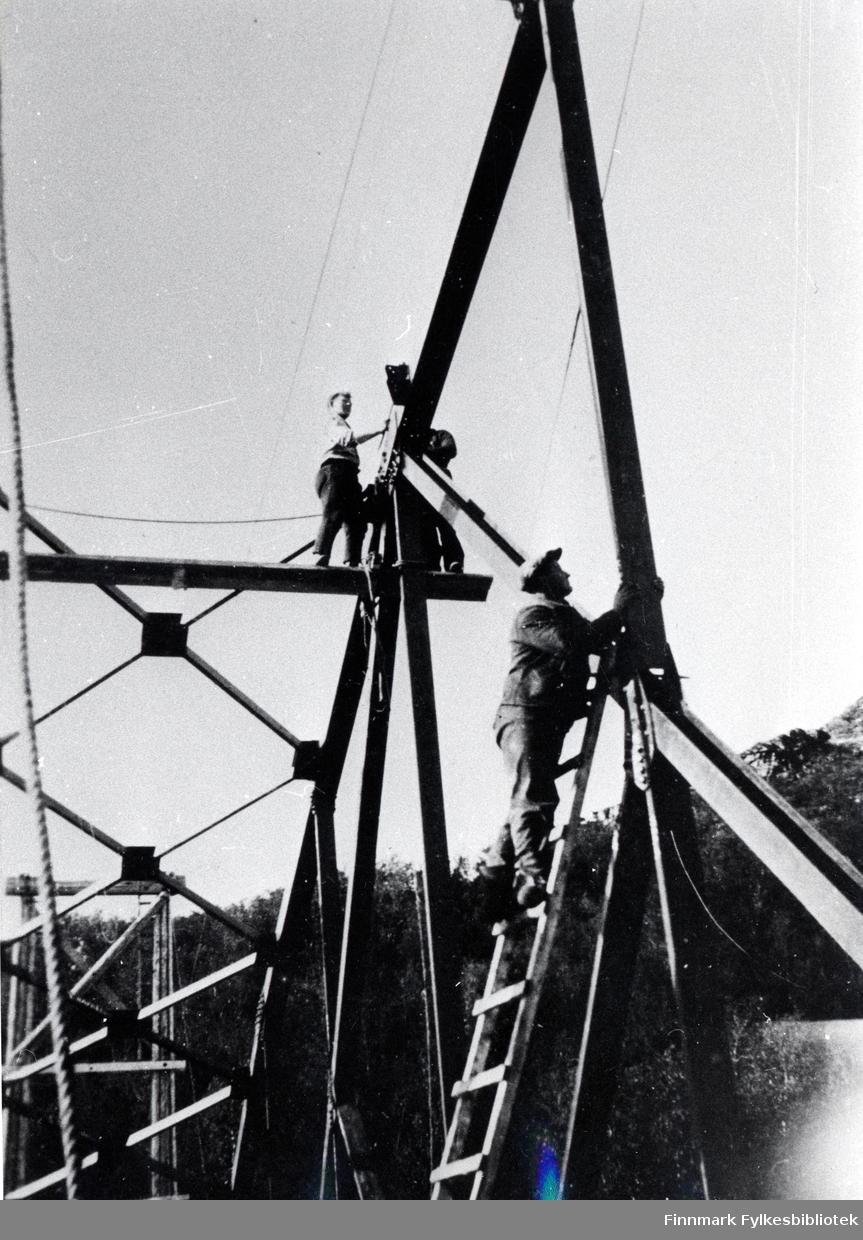 Bruarbeid Stabburselv, i Kistrand i porsanger i 1933. På bildet ser man to menn som arbeider på bruen. Den ene står oppe i en stige, den andre står på en bjelke. Se også bilde 716.