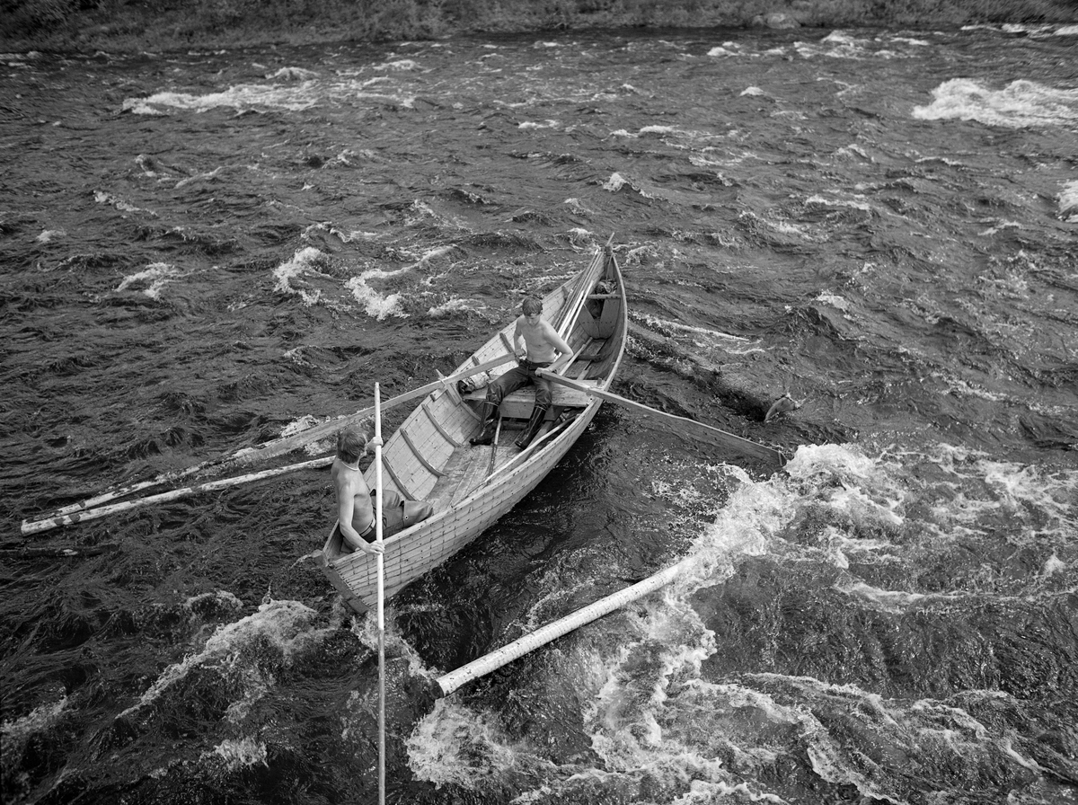 Sluttrensk i elva Stor-Grøna i Trysil, Hedmark. Fløtere på veg ned elva i båt.