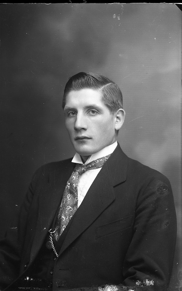 Porträtt av en ung man med kostym och slips.
