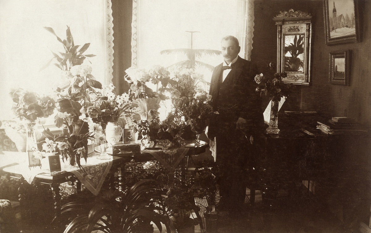 Landsfiskal Gustaf Herrlin, Åseda, poserar i sitt vardagsrum på 50-årsdagen, 24 april 1919.