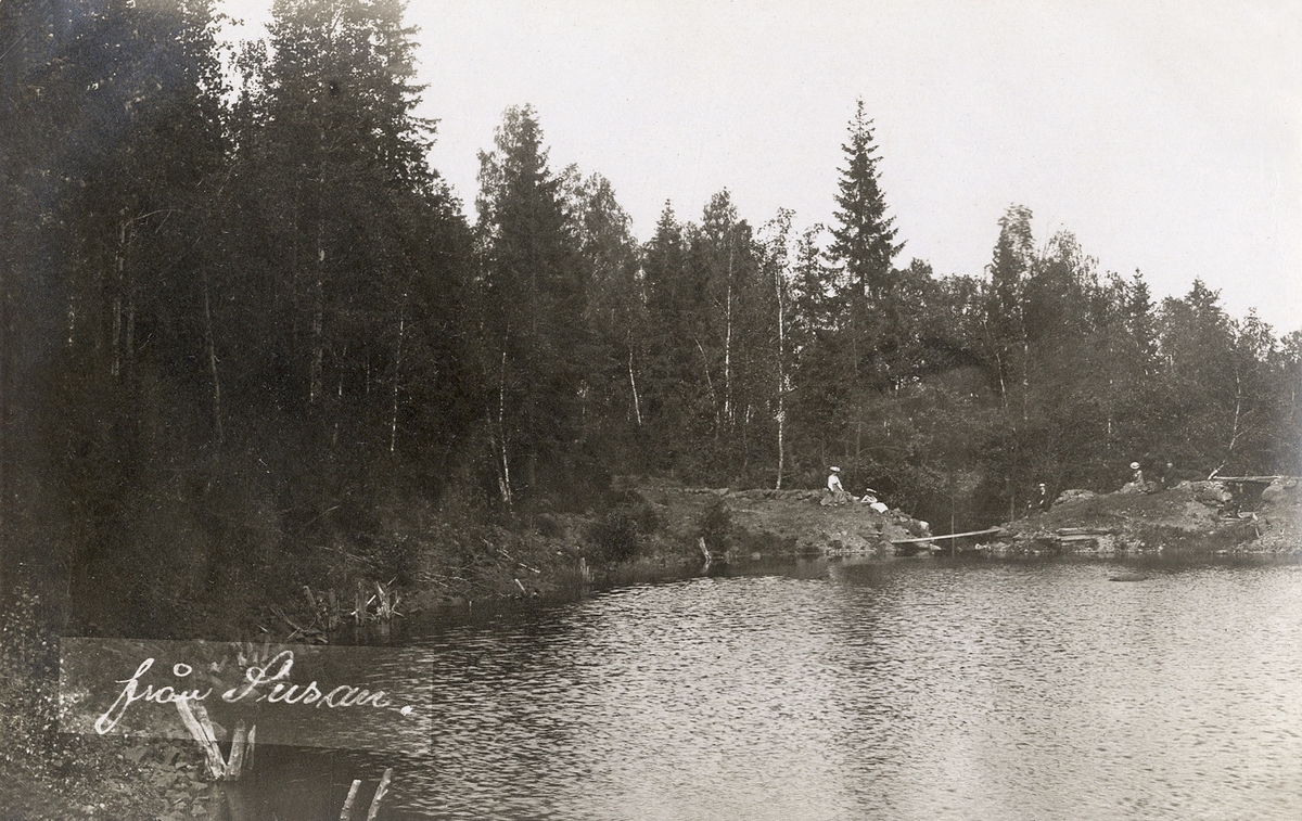 Några personer på utflykt sitter på några klippor vid en sjö. Ca 1905 ...