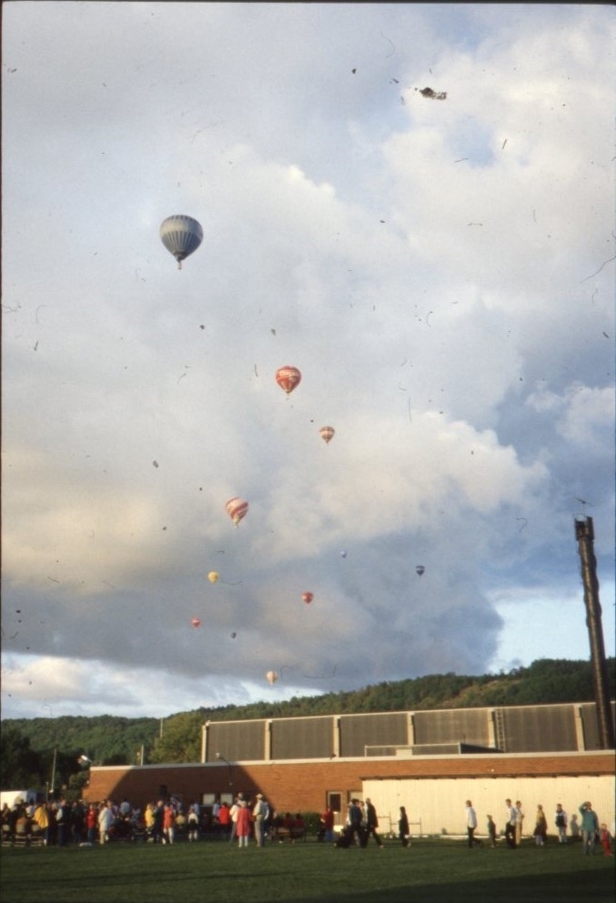 Vy mot Ribbahallen där flera människor står och kollar på flygande luftballonger.