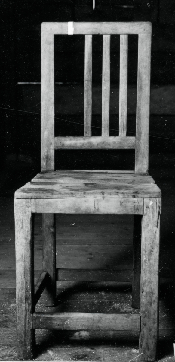 Omålad stol med rygg bestående av 4 st vertikala spjälor varav en saknas, Raka 4-sidiga ben med lågt sittande tvärslåar,  
Neg nr 81/1053:4