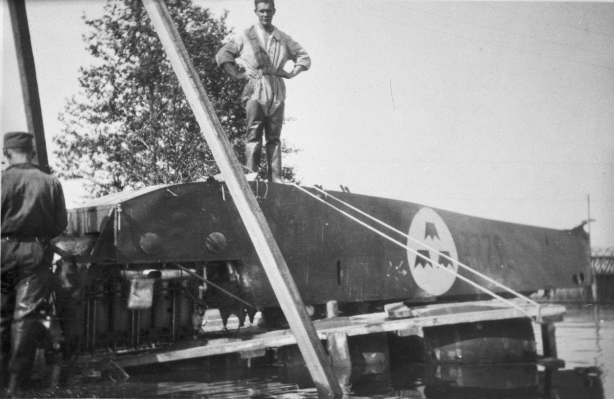 Bärgning av flygplan S 1/ S 25H märkt nummer 3222 vid Nybro efter haveri 28 juni 1927. En man står på det upp- och nedvända flygplanet.