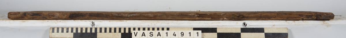Bräda som tillhör alpumpkistan i hålskeppet. Stor längsgående spricka vilken separerar detta föremål från 14734. En del skador på kanterna.